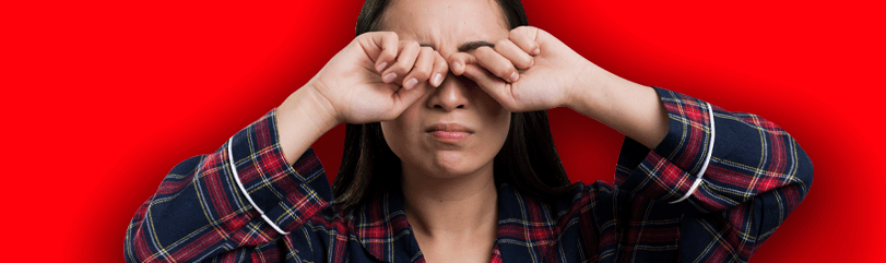 Cuidados com pomadas capilares - mulher coçando os olhos, com os olhos irritados em um fundo vermelho